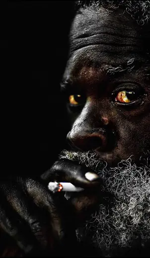 Retrato em contraluz de um homem idoso de barba branca.