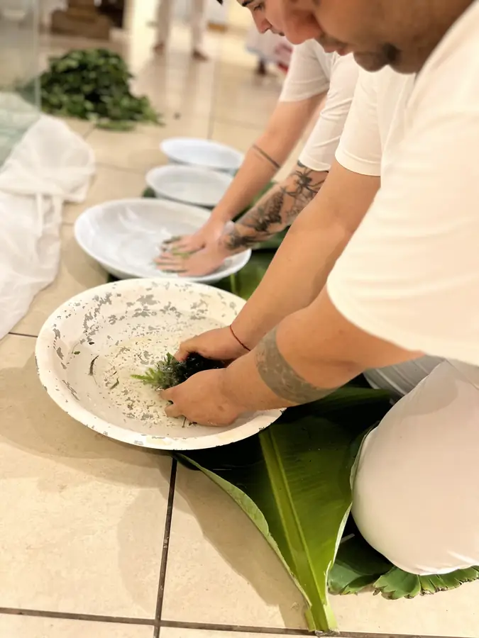 Pratos de oferenda dispostos sobre folhas de bananeira no chão.